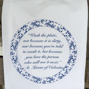 Folded white flour sack tea towel with Saint Teresa of Calcutta quote in blue