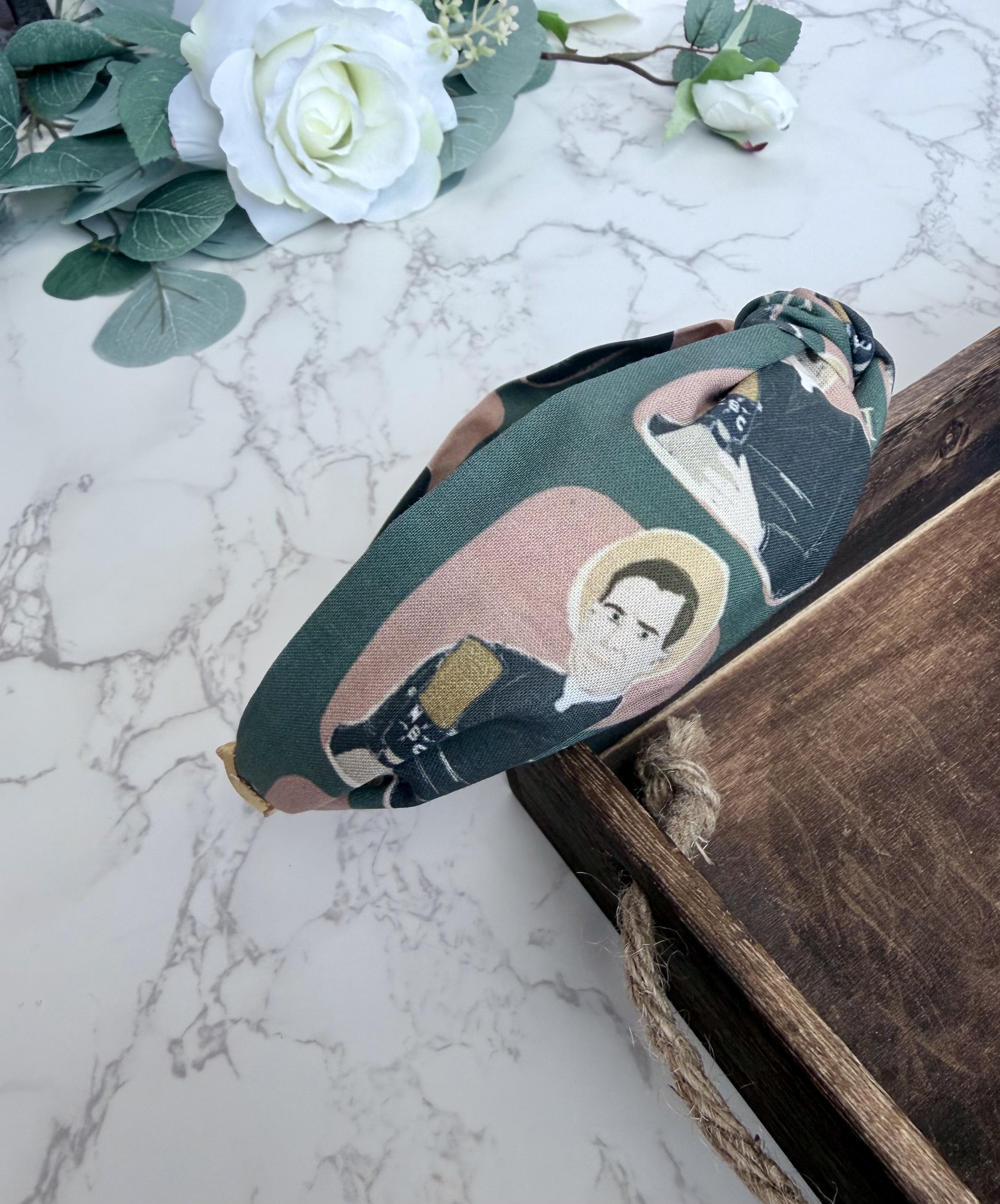 Knotted headband featuring the image of Fulton Sheen speaking into a microphone on a dark green background.