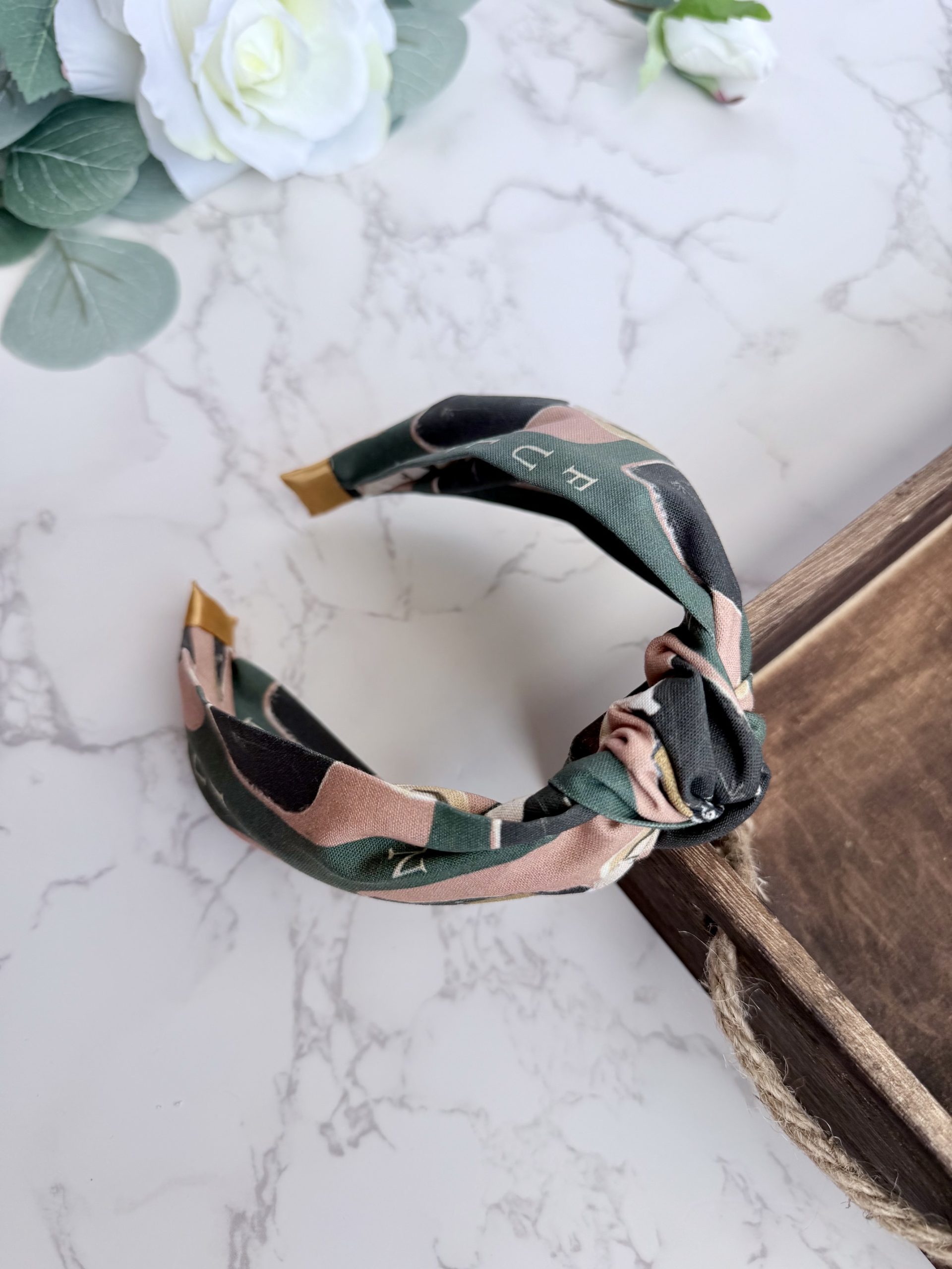 Knotted headband featuring the image of Fulton Sheen speaking into a microphone on a dark green background.