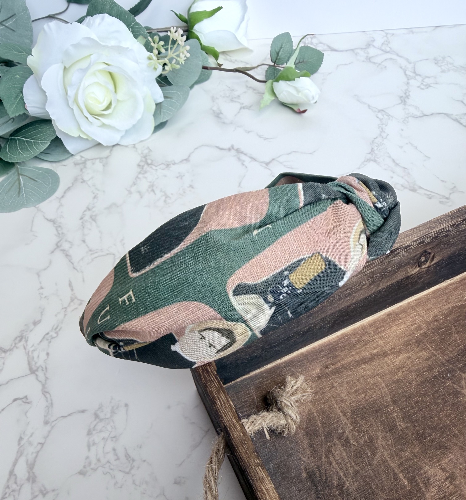 Knotted headband featuring the image of Fulton Sheen speaking into a microphone on a dark green background.