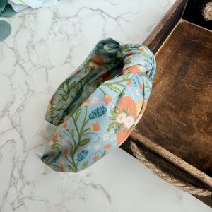 Knotted headband with images of the Immaculate Heart of Mary surrounded by a lovely floral pattern on a blue gray background.