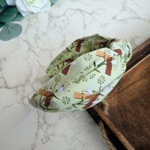 Light green knotted headband with images of carpenter square and lily.