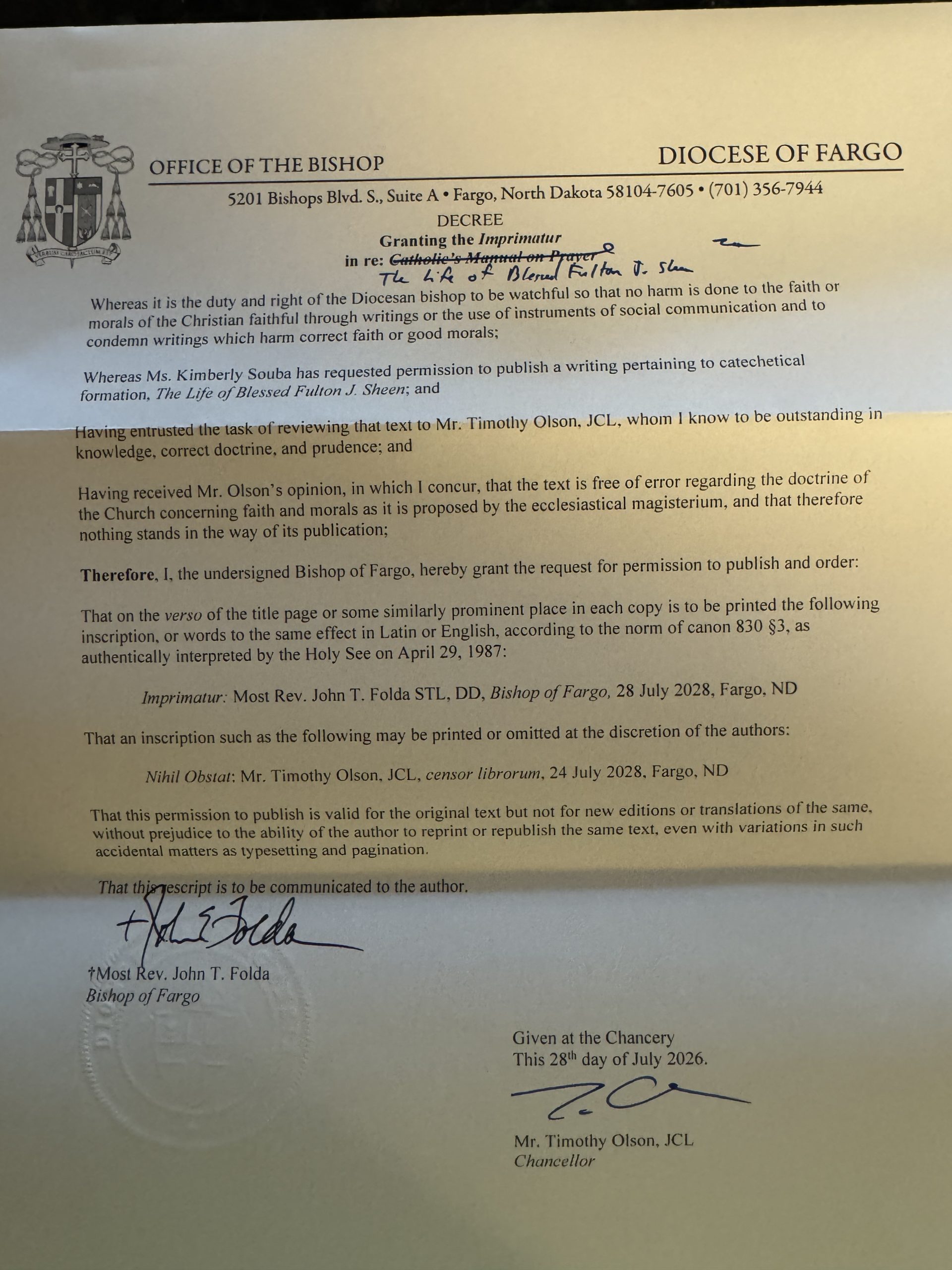 Photograph of an official Diocese of Fargo decree granting the Imprimatur for Kimberly Souba’s book, The Life of Blessed Fulton J. Sheen. The document is signed by Bishop John T. Folda and Chancellor Timothy Olson and dated July 28, 2026.